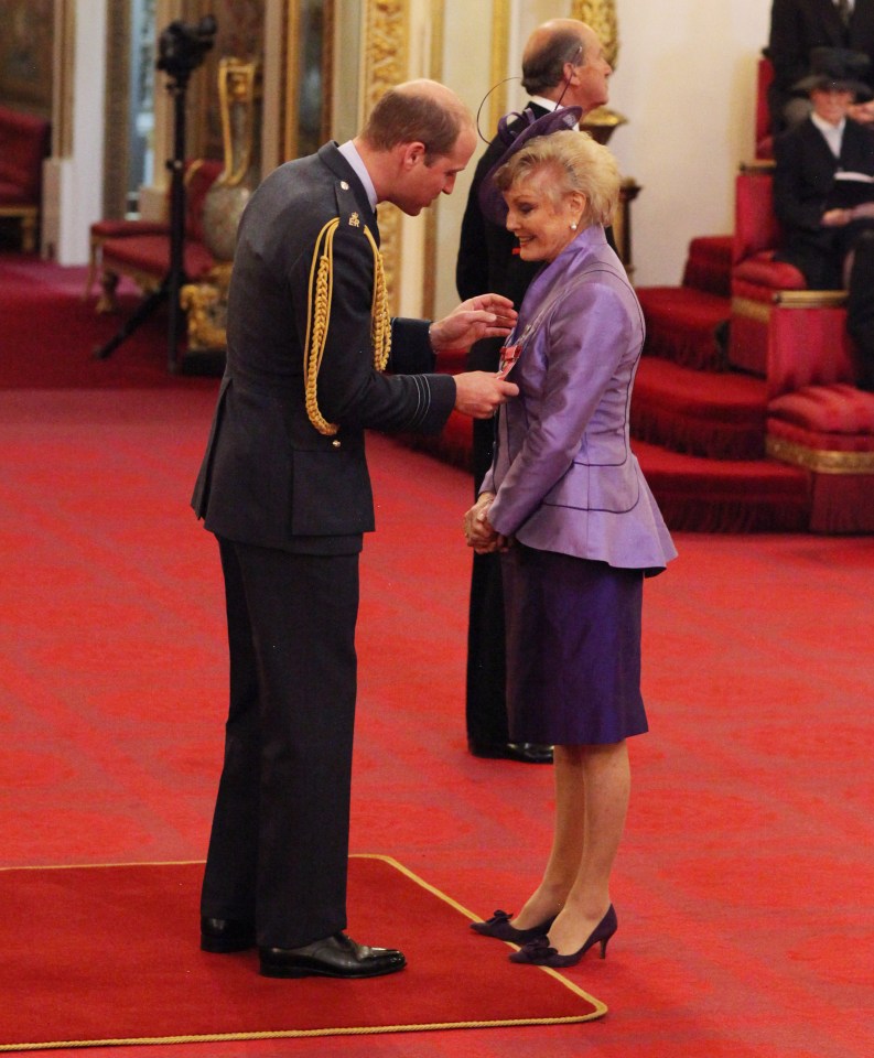 a man in a military uniform is giving a woman a medal