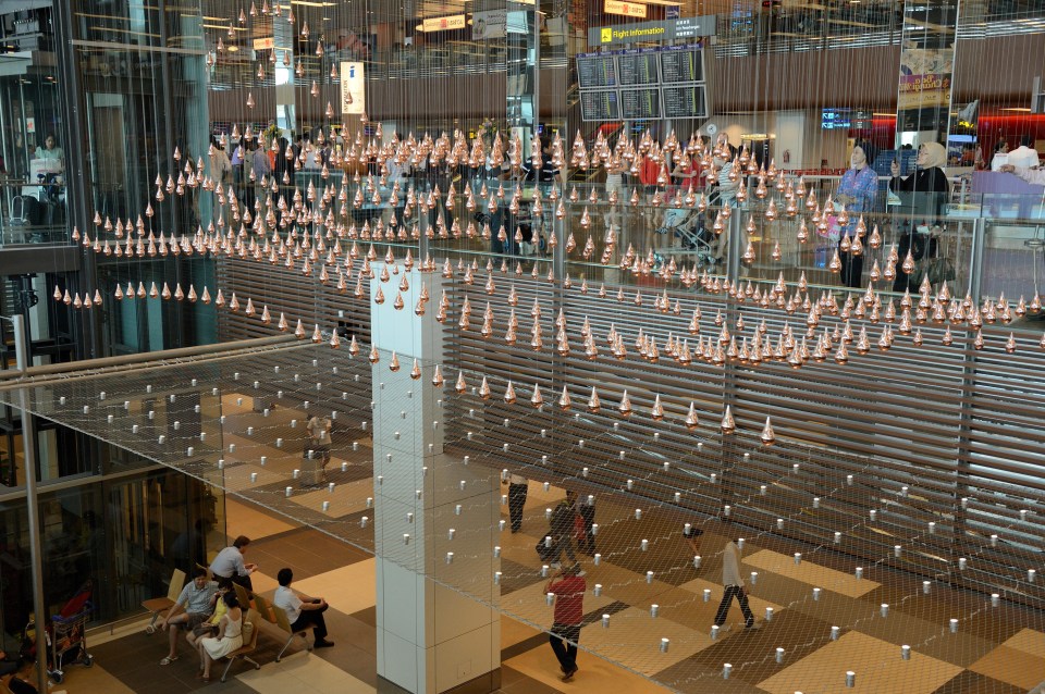 a large display of cones hangs from the ceiling of an airport