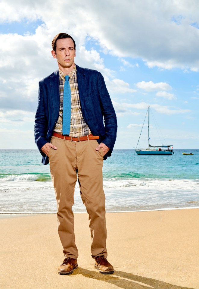 a man standing on a beach with his hands in his pockets