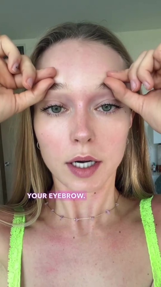 a woman in a neon green tank top is holding her eyebrows