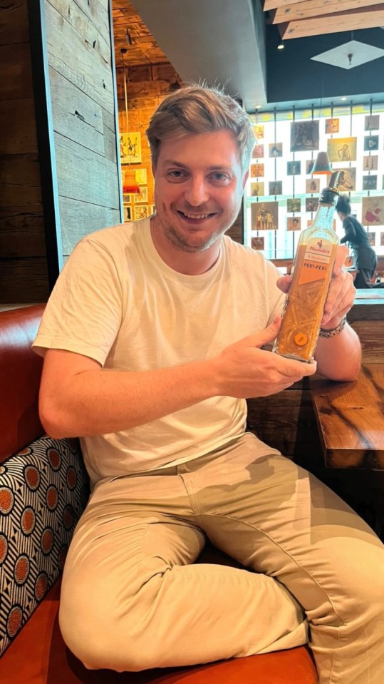 a man is holding a bottle of ferrero rocher