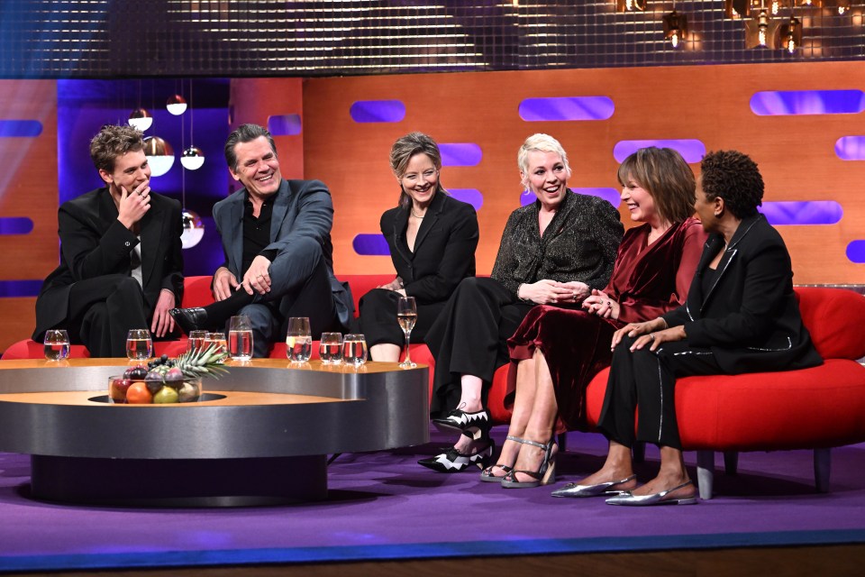 a group of people are sitting on a red couch