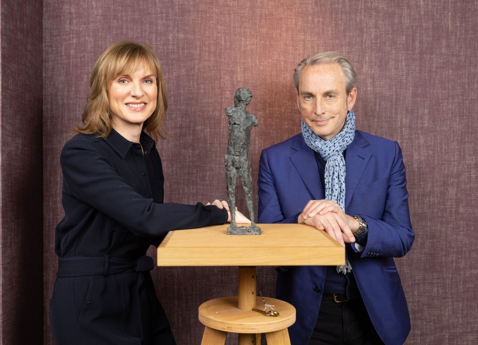 a man and a woman standing next to a statue