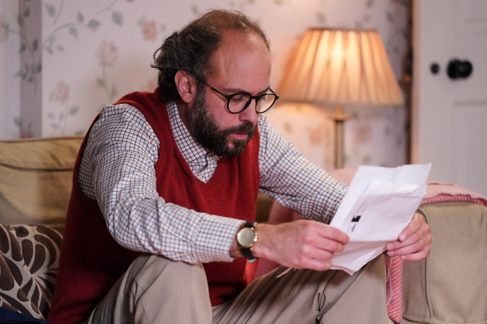 a man sitting on a couch looking at a piece of paper