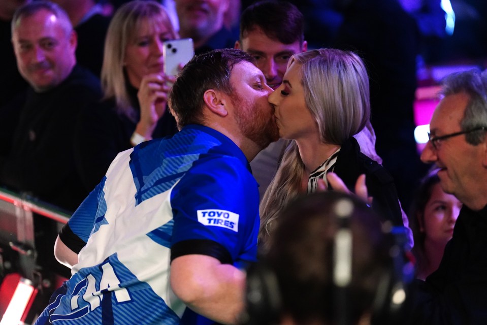 a man wearing a shirt that says toyo tires kisses a woman