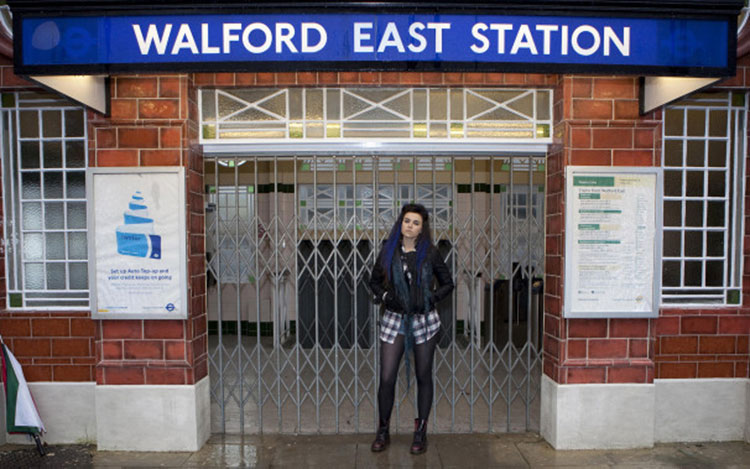 a woman stands in front of the walford east station