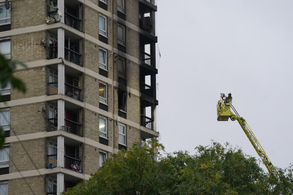 a tall building with a yellow crane in front of it