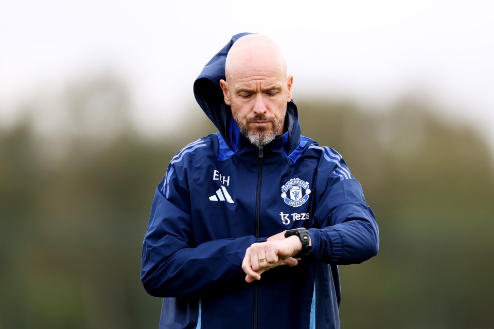 a man in a manchester united jacket looks at his watch