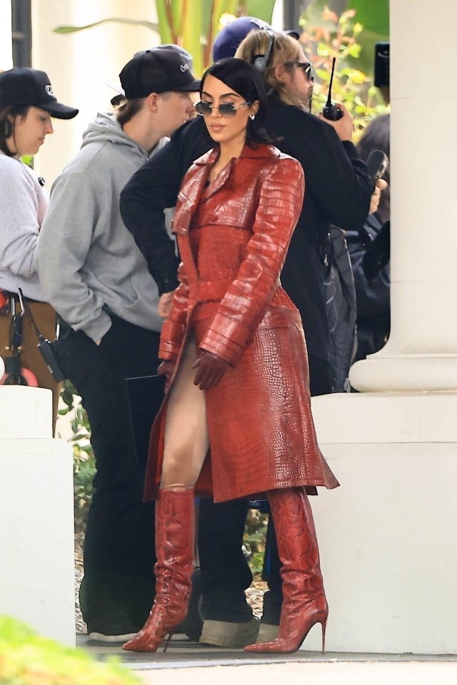 a woman wearing a red trench coat and red boots