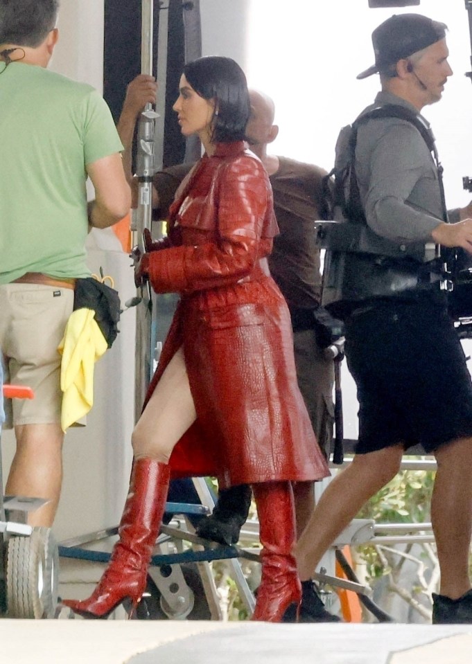 a woman wearing a red coat and red boots