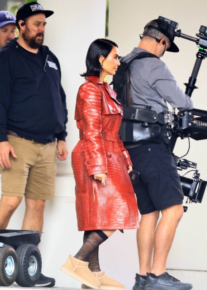 a woman in a red trench coat is being filmed