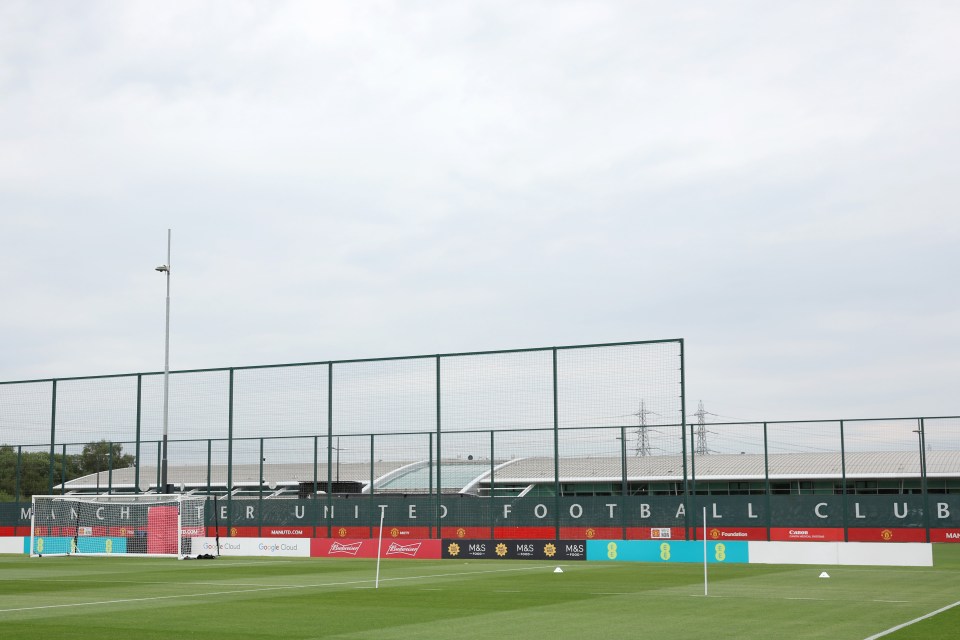 a fence surrounds a soccer field that says manchester united football club