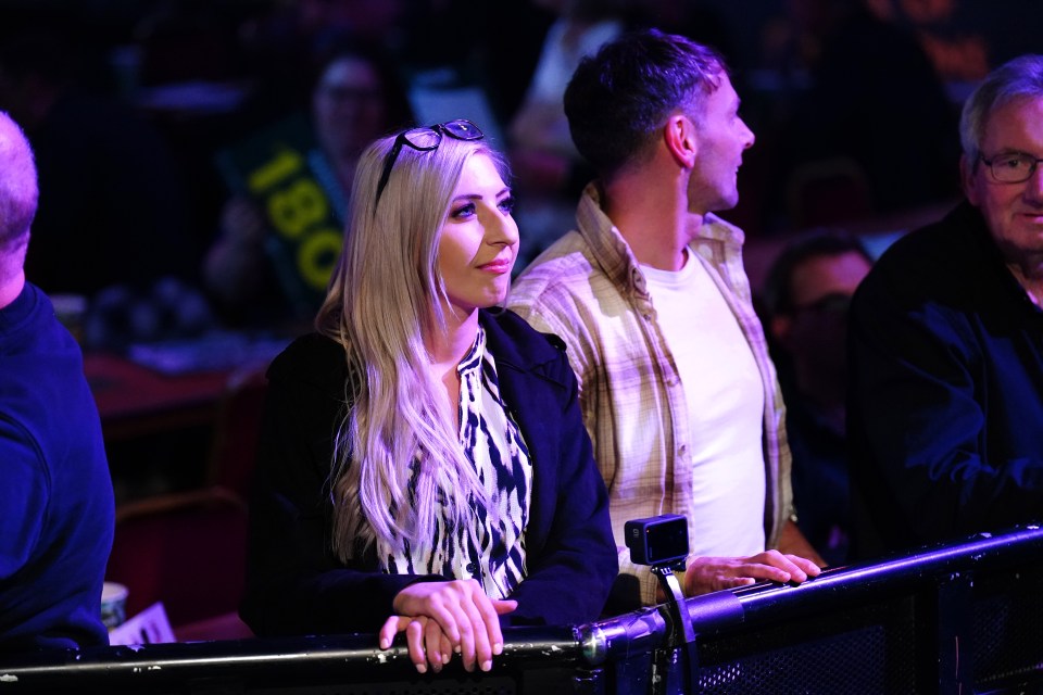 a man and a woman sit in a stadium with a green banner that says ibc on it