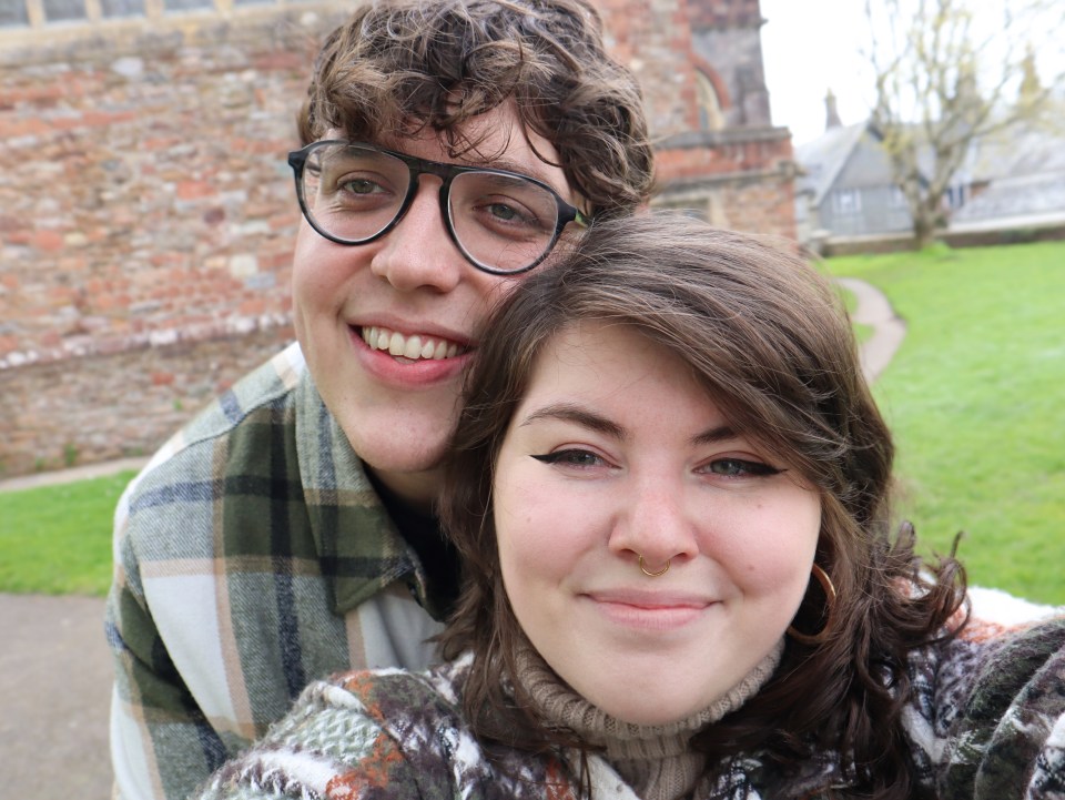 a man and a woman are posing for a picture and smiling