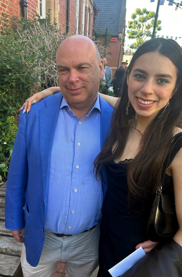 a man in a blue jacket stands next to a woman in a black dress