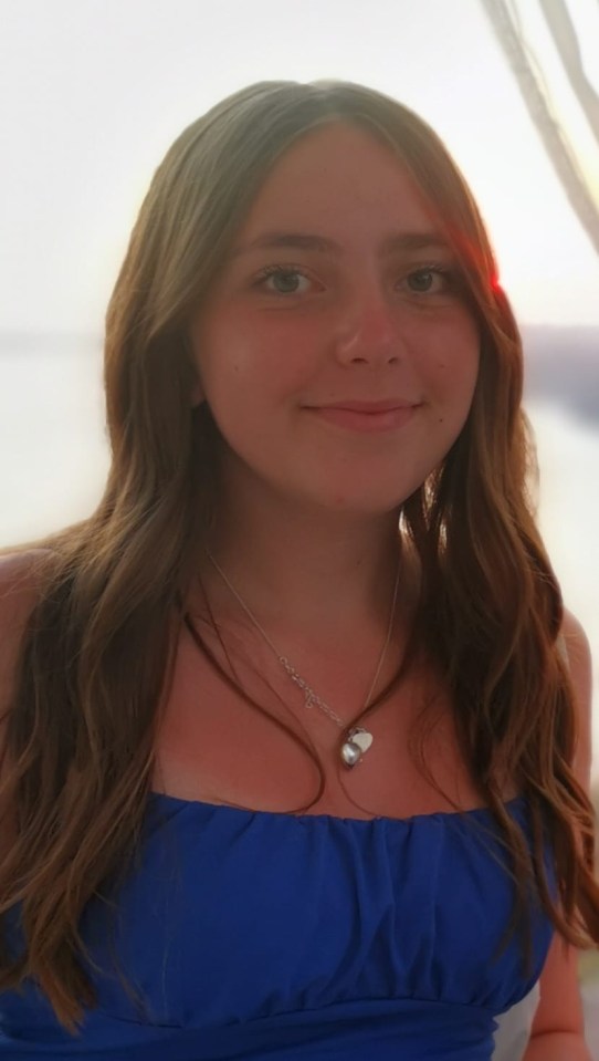 a girl wearing a blue top and a silver necklace