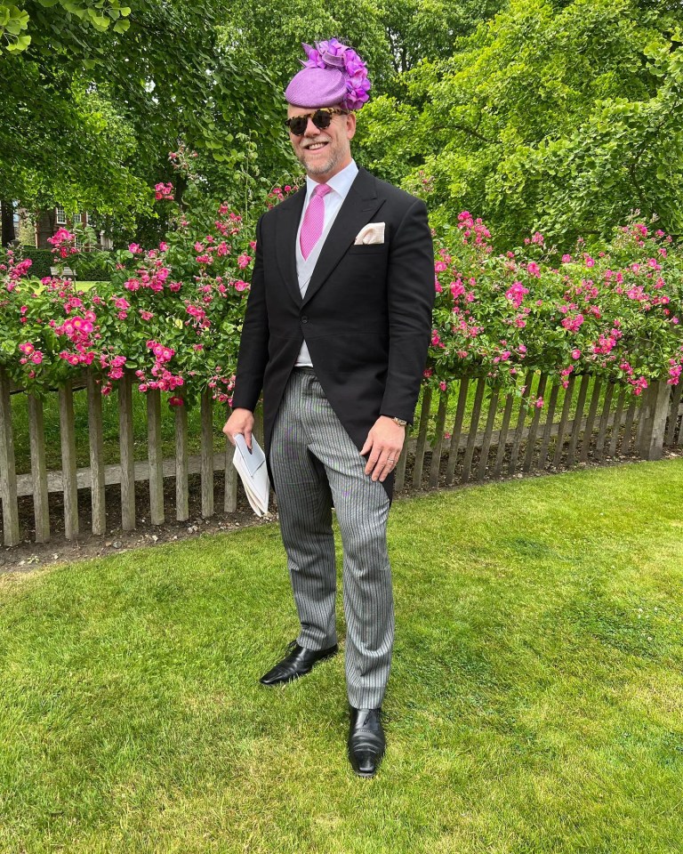 a man wearing a black suit and a purple hat