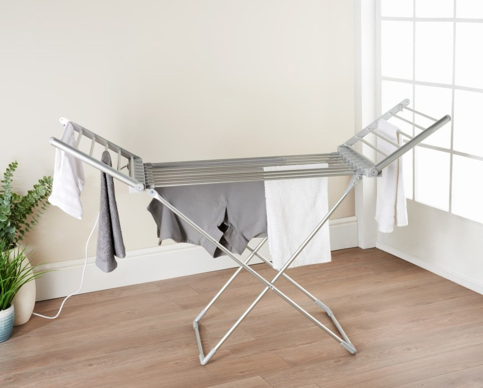 a clothes drying rack with clothes hanging on it