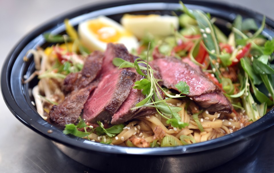 a close up of a bowl of food with meat and noodles