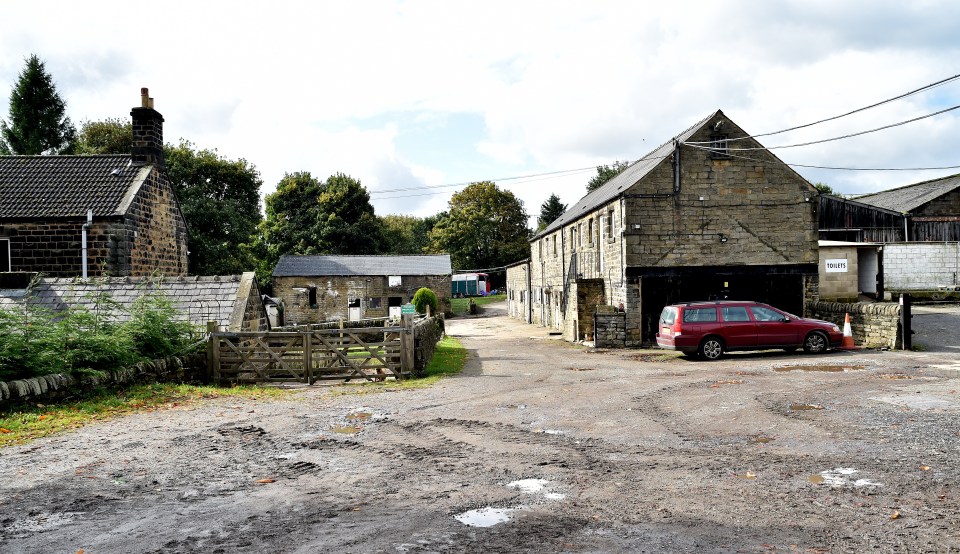 a red car is parked in front of a stone building with a sign on it that says ' warehouse '