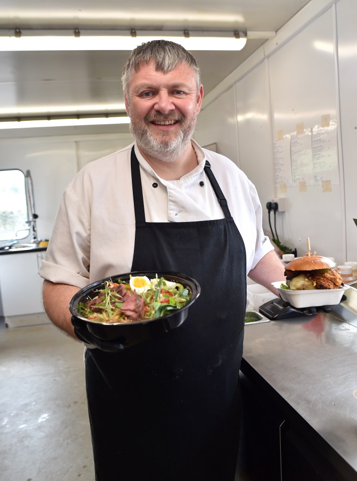 a man in an apron is holding a bowl of food