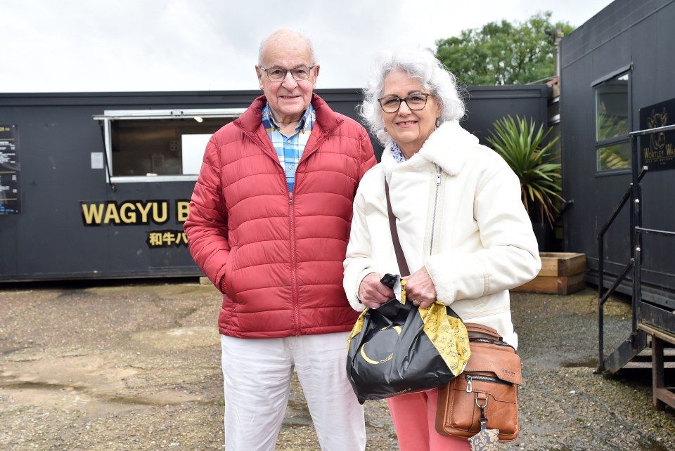 a man and woman standing in front of a building that says wagyu