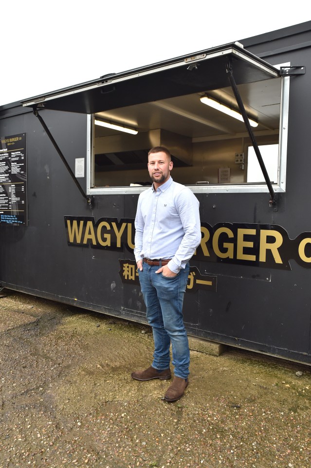 a man stands in front of a wagyu burger restaurant