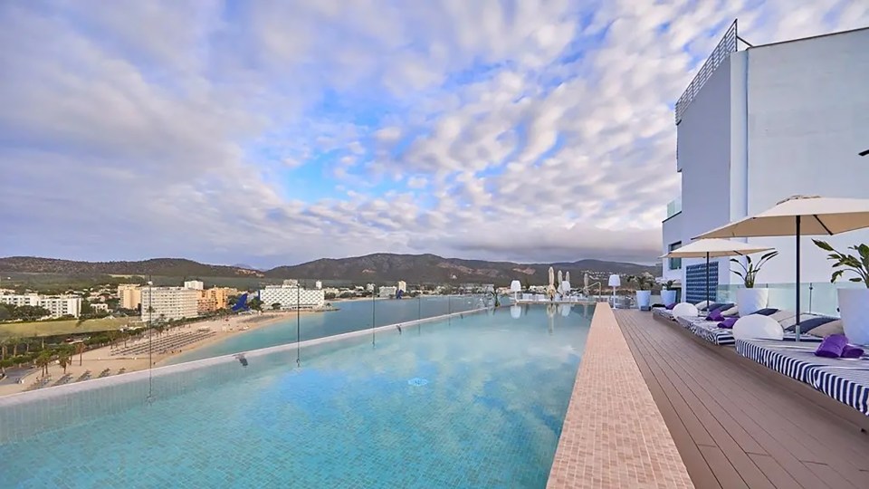 a swimming pool with a view of a city and mountains