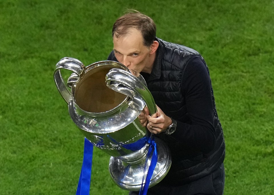 a man kisses a trophy that says ' champions league ' on it