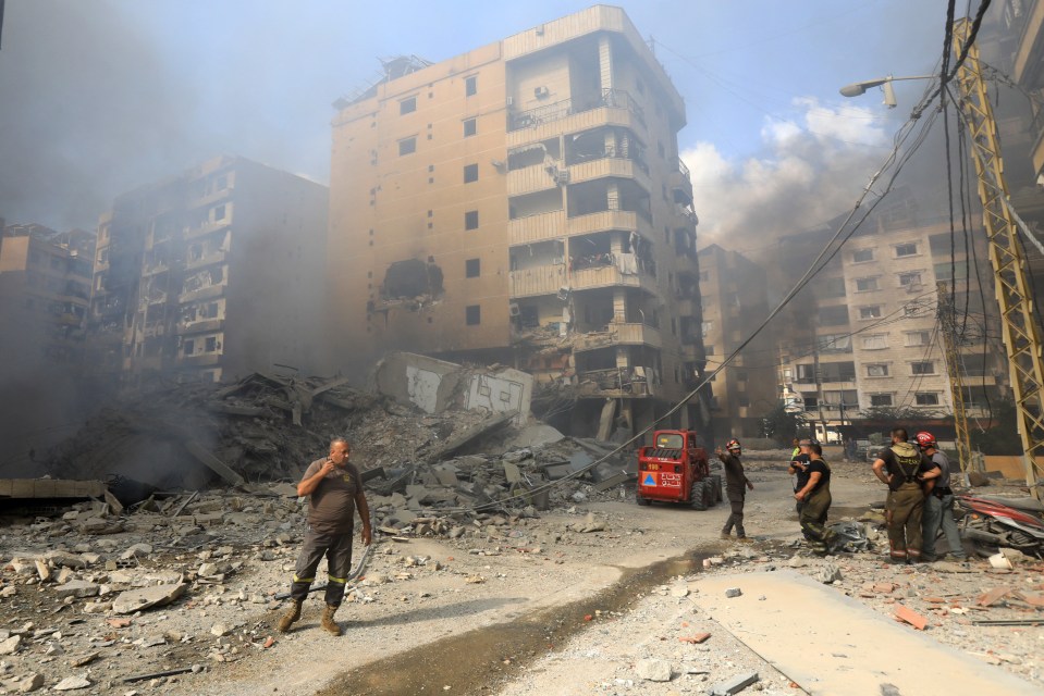 Firefighters work at the site of an overnight Israeli airstrike in Beirut's southern suburb of Shayyah