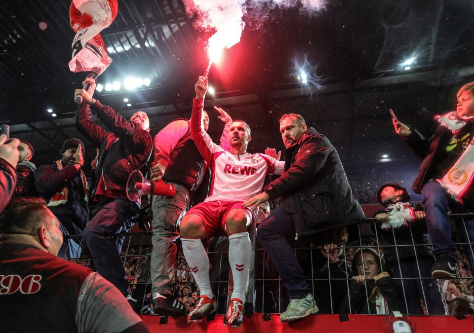 COLOGNE, GERMANY - OCTOBER 10: Lukas Podolski farewell on the fence with pyrotechnic fireworks from the Ultras Fans of Cologne during the Farewell Game Of Lukas Podolski 1.FC Köln on October 10, 2024 in Cologne, Germany. (Photo by Jürgen Fromme - firo sportphoto/Getty Images)