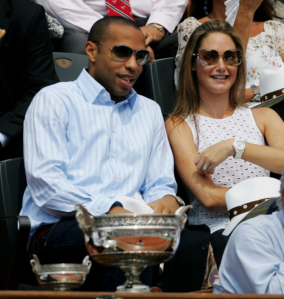 a man and a woman wearing sunglasses sit in a stadium