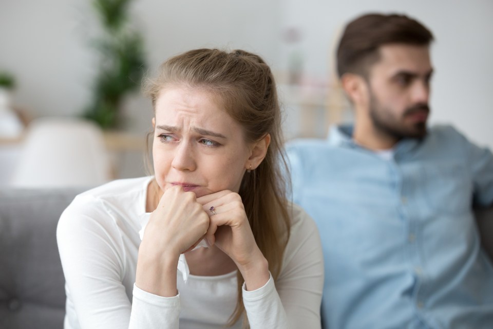 a woman with a ring on her finger sits next to a man