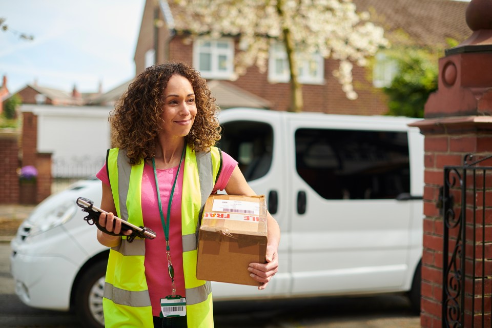 a woman holding a cardboard box with fragile written on it