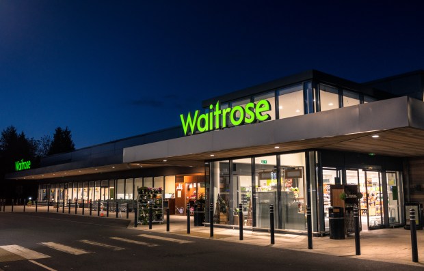 the outside of a waitrose store at night