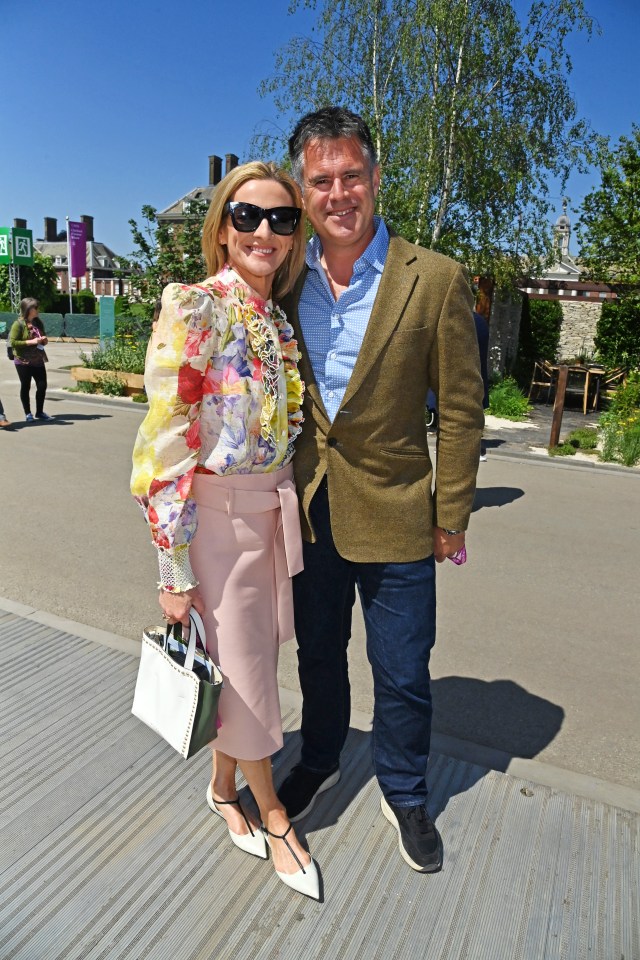 a man and a woman pose for a picture in front of a sign that says ' a ' on it