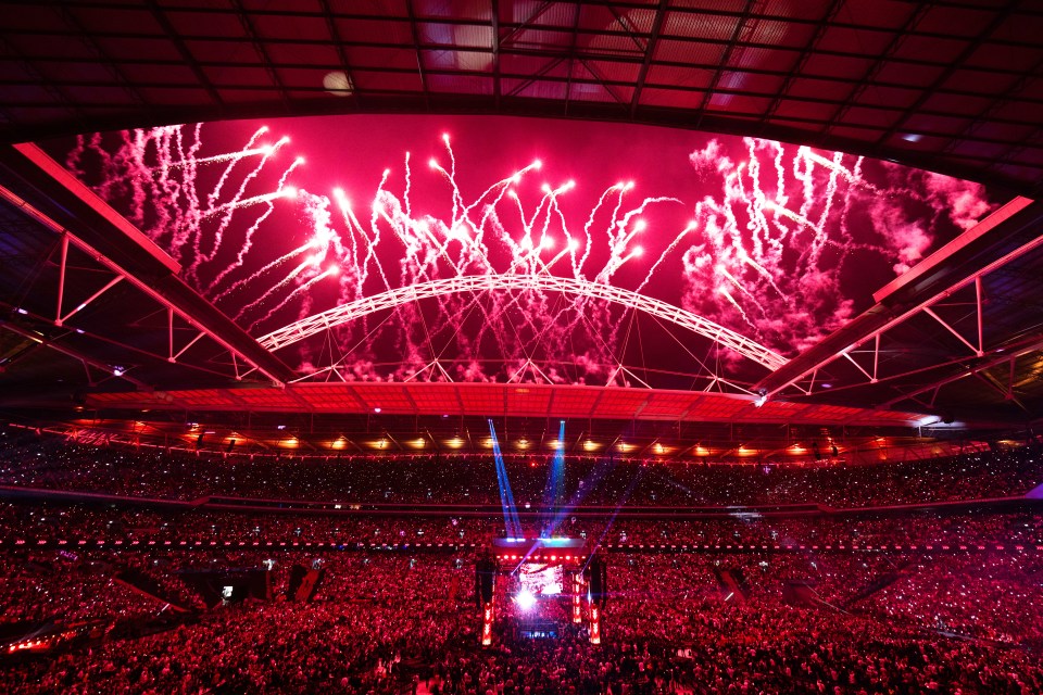 a crowd of people watching fireworks in a stadium