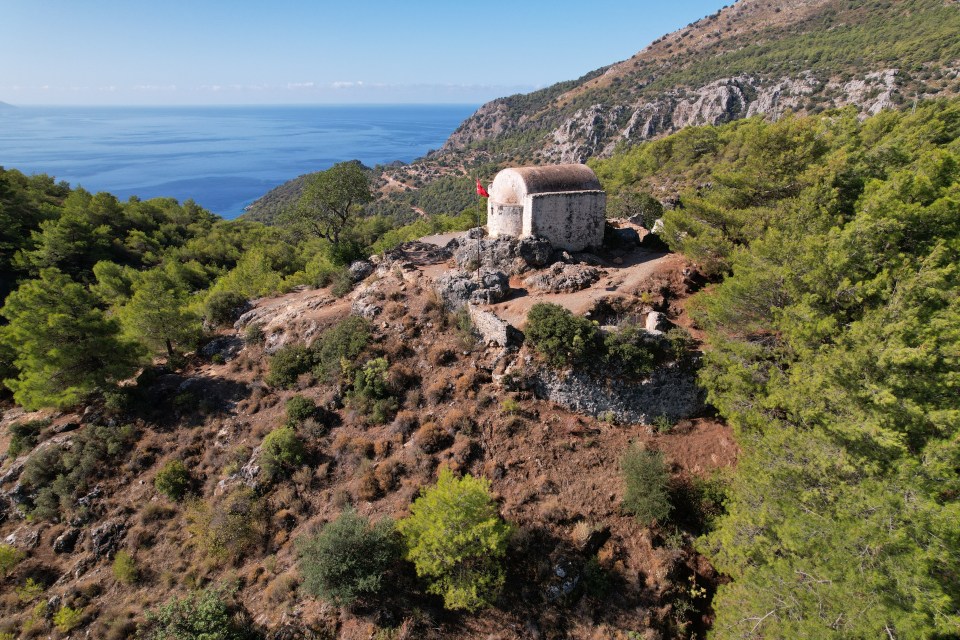 a small building on top of a hill overlooking the ocean