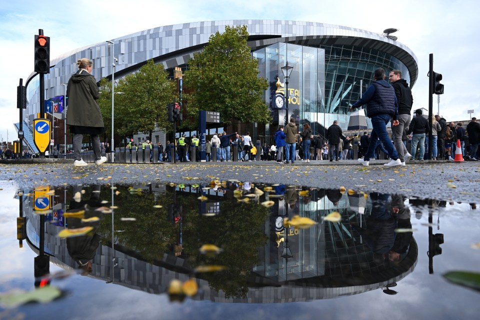 a reflection of the tottenham hotspur stadium in a puddle