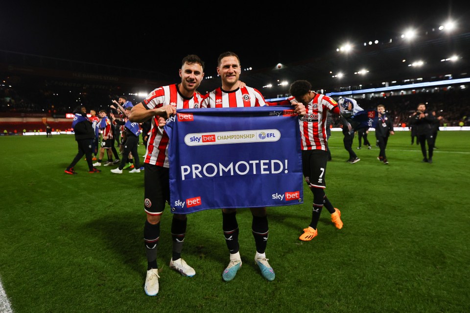 two soccer players holding a sign that says promoted