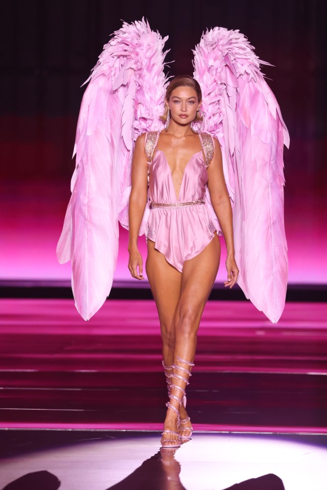 a woman in a pink bodysuit with pink angel wings