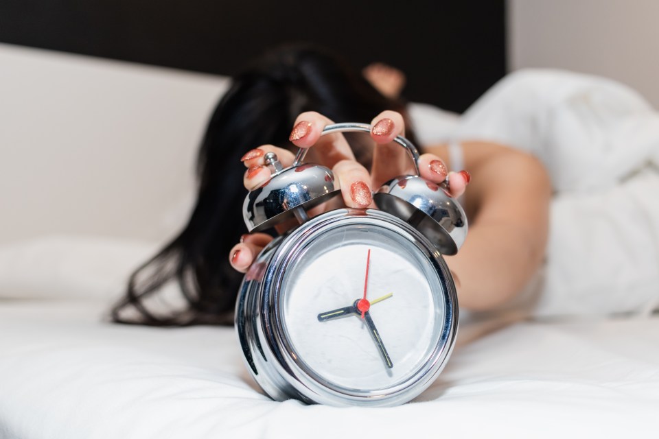 a woman is holding an alarm clock which shows the time as 4:20