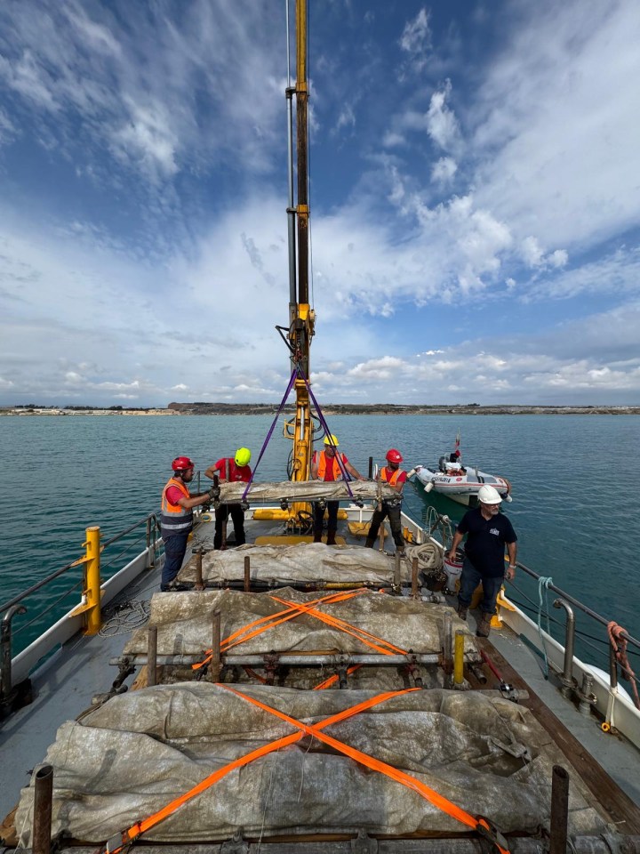 a group of men are working on a boat in the water