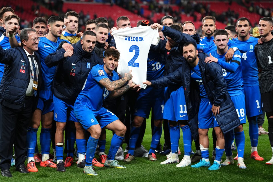 Greece players holding up a shirt in memory of George Baldock at Wembley tonight