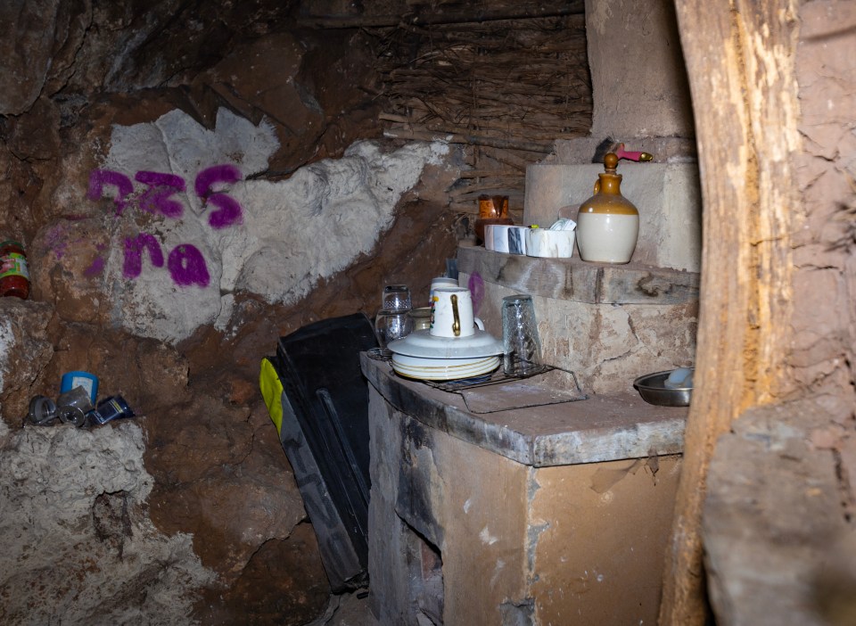 a dirty kitchen with a wall that has the word na written on it