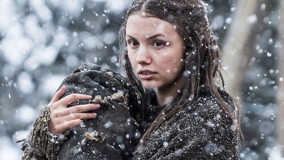 a woman in a sweater is standing in the snow