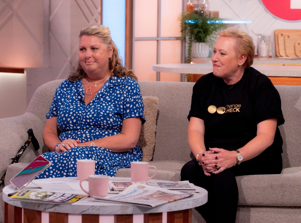 two women sit on a couch with one wearing a shirt that says theatre check