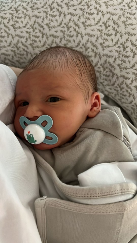 a newborn baby with a pacifier in his mouth