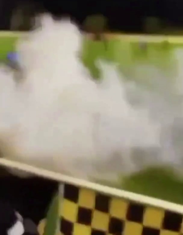 a close up of a person riding a roller coaster with smoke coming out of it .