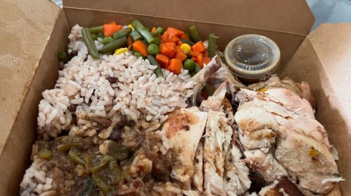 a box of food with rice , beans , carrots and peas .